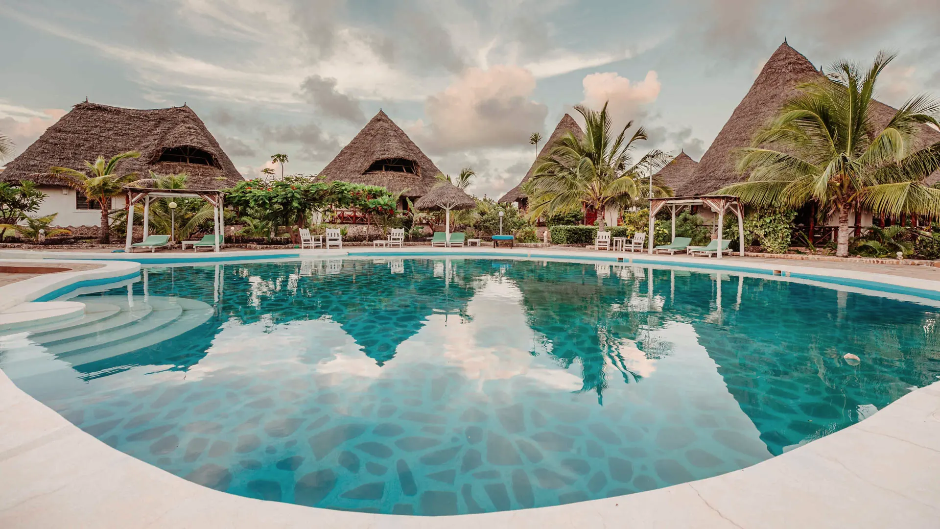 The central pool reflecting the thatched roofs of the villas