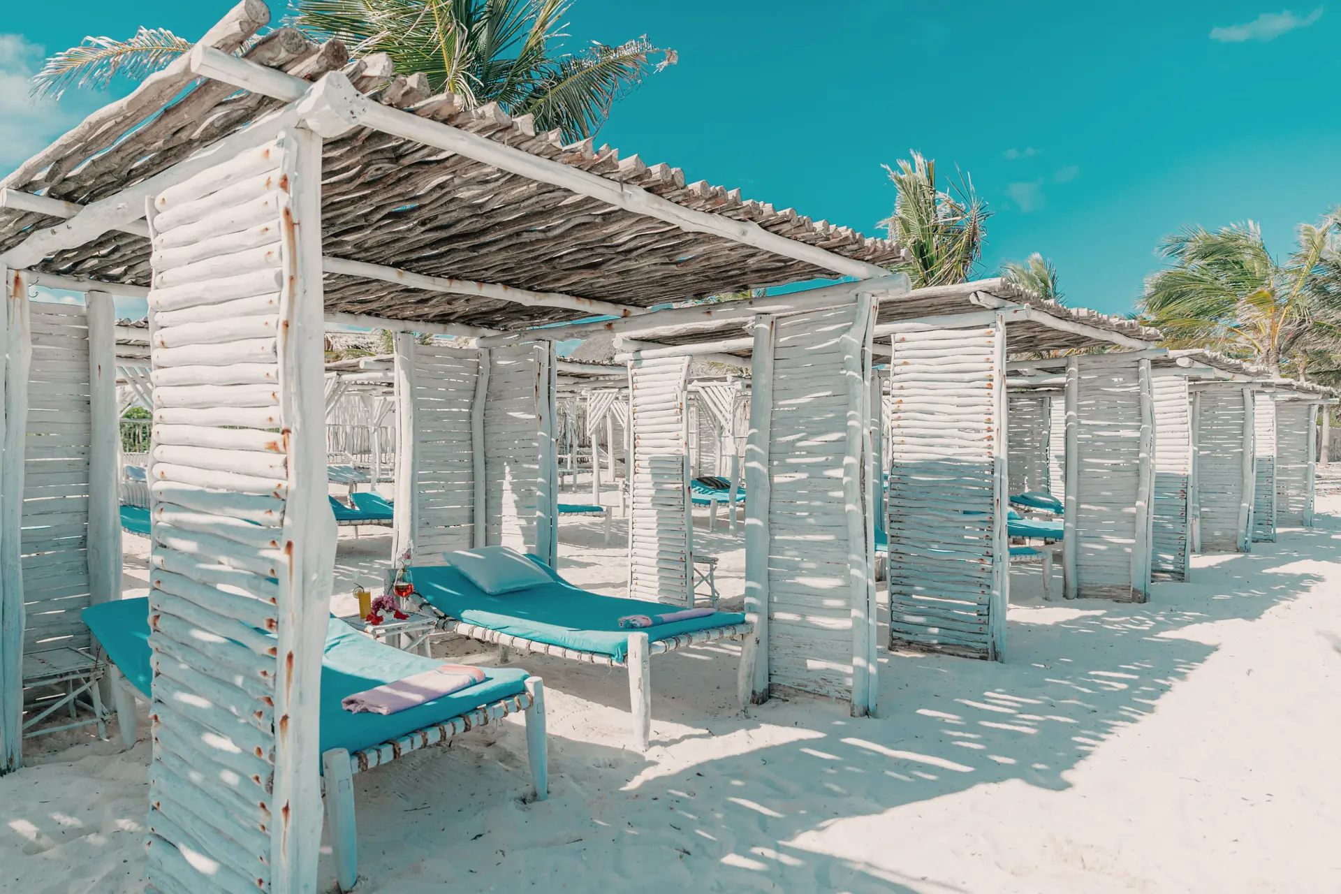 Whitewashed gazebos and sunbeds in the shade at the beach club